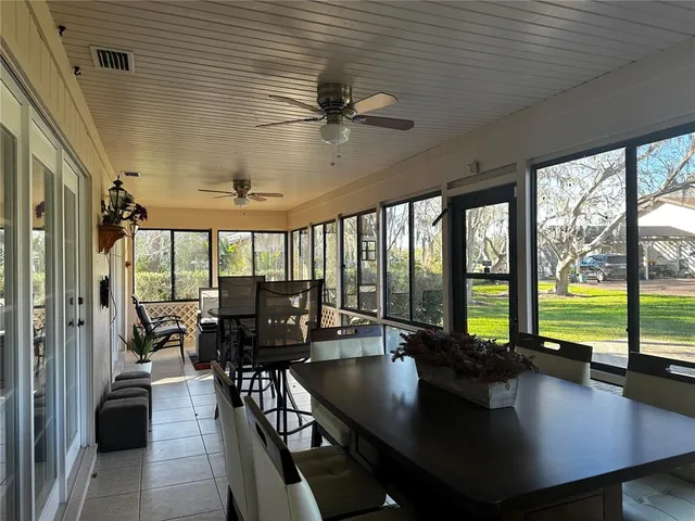 a living room with furniture floor to ceiling window and a table