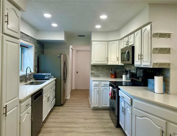 a kitchen with stainless steel appliances granite countertop a sink stove and refrigerator