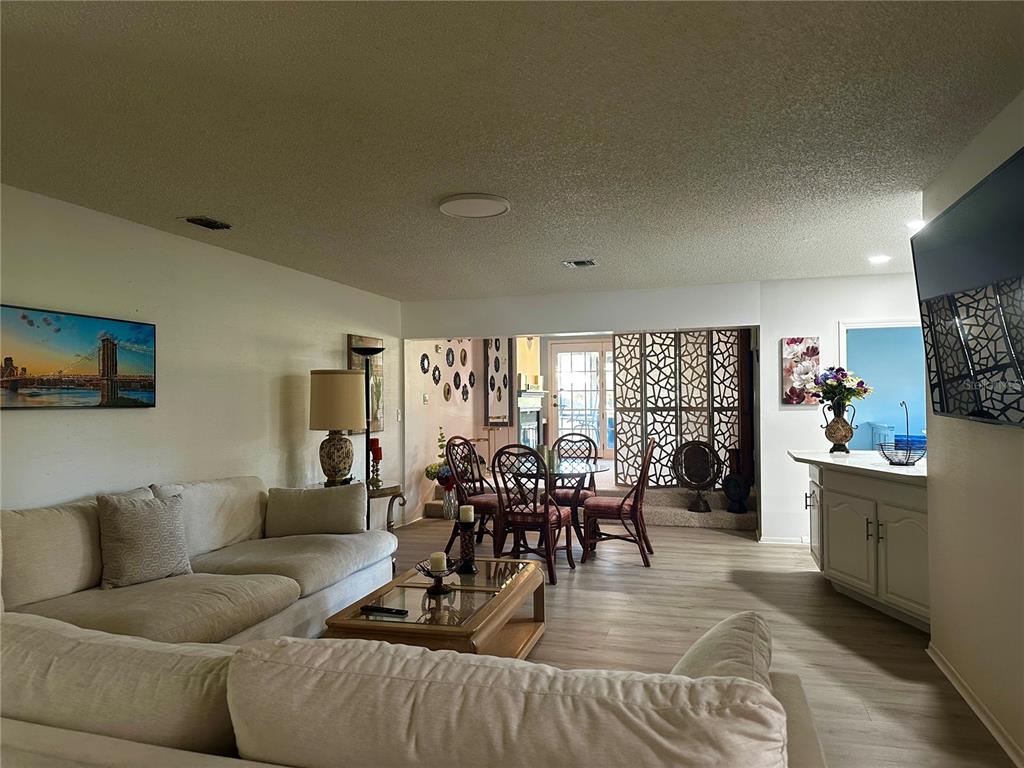 5144 Pine Tree Lane Wesley Chapel, FL 33543 - Photo 4 of 13 a living room with furniture dining area and a large window
