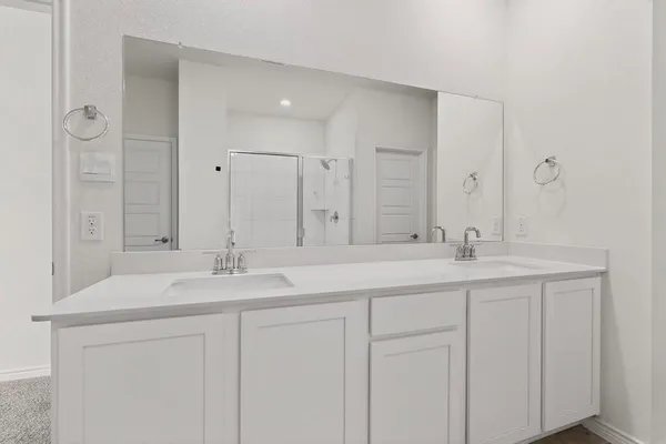 a bathroom with double sink and a mirror