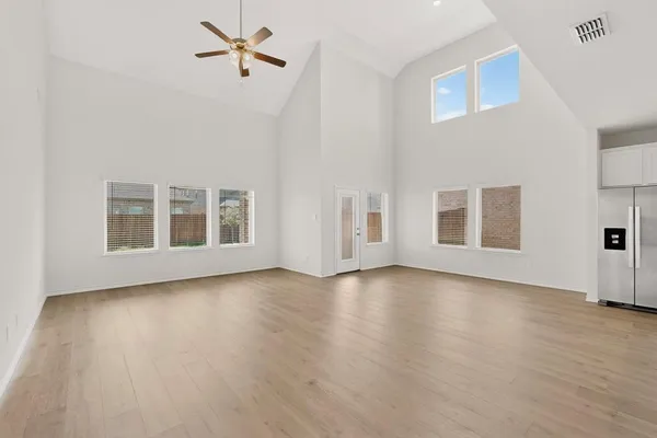 a view of a livingroom with wooden floor and a ceiling fan