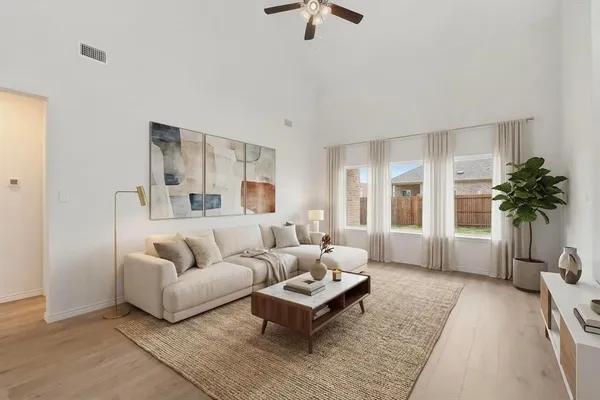 a living room with furniture potted plant and a large window