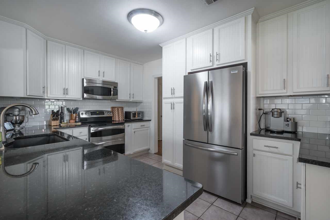 154 North Rose Road Memphis, TN 38117 - Photo 9 of 23 a kitchen with a refrigerator a stove a sink and cabinets