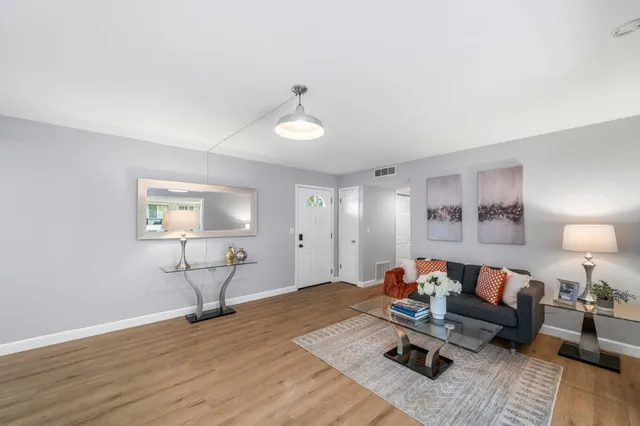 a living room with furniture and a wooden floor