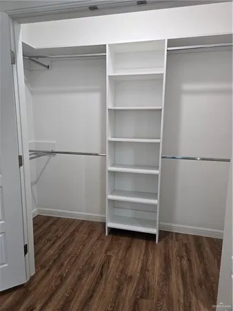 a view of walk in closet with empty racks