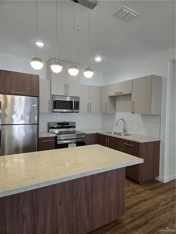 a kitchen with stainless steel appliances a microwave a sink and a refrigerator