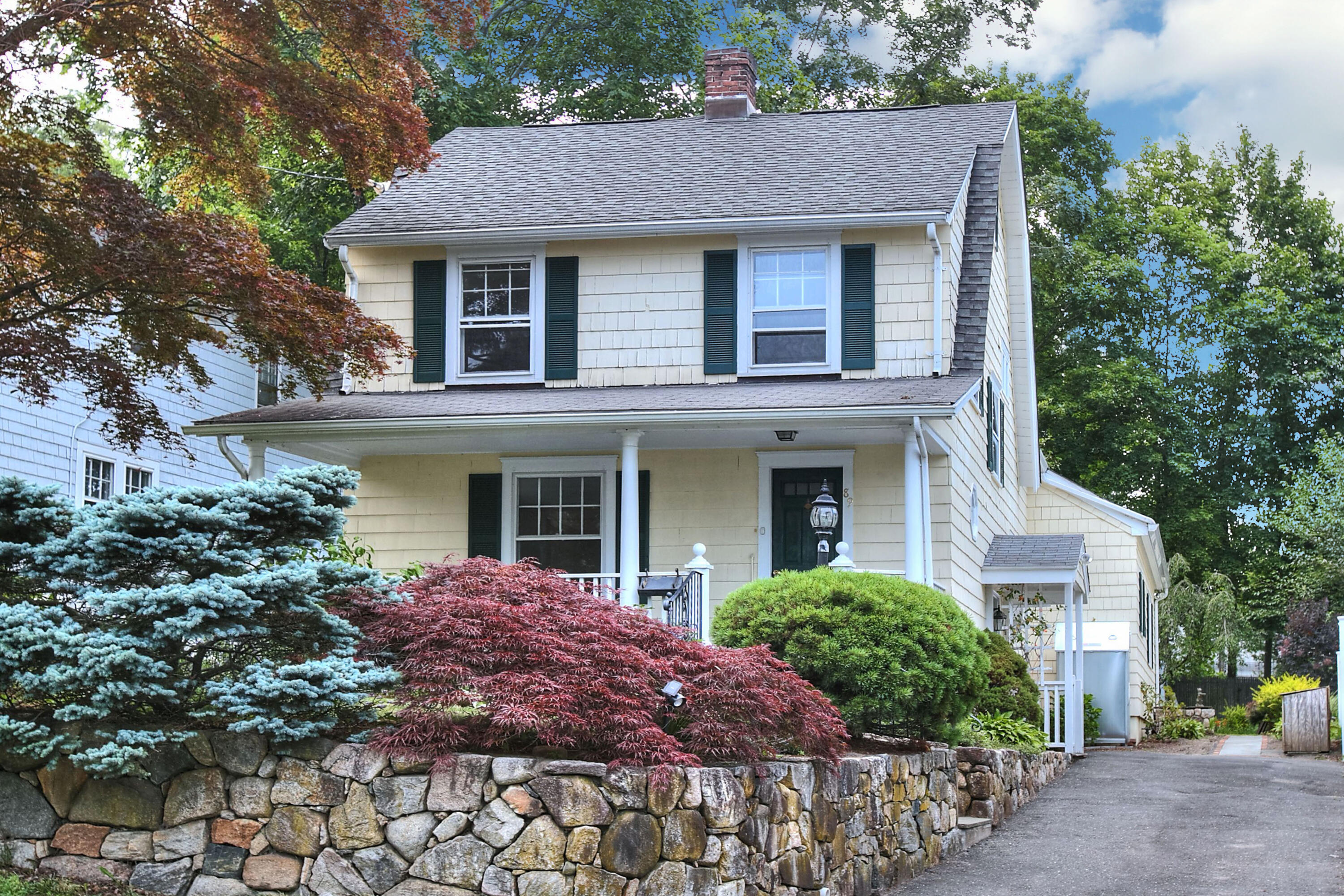 89 Richmond Hill Road New Canaan, CT 06840 - Photo 3 of 40 a front view of a house with a garden