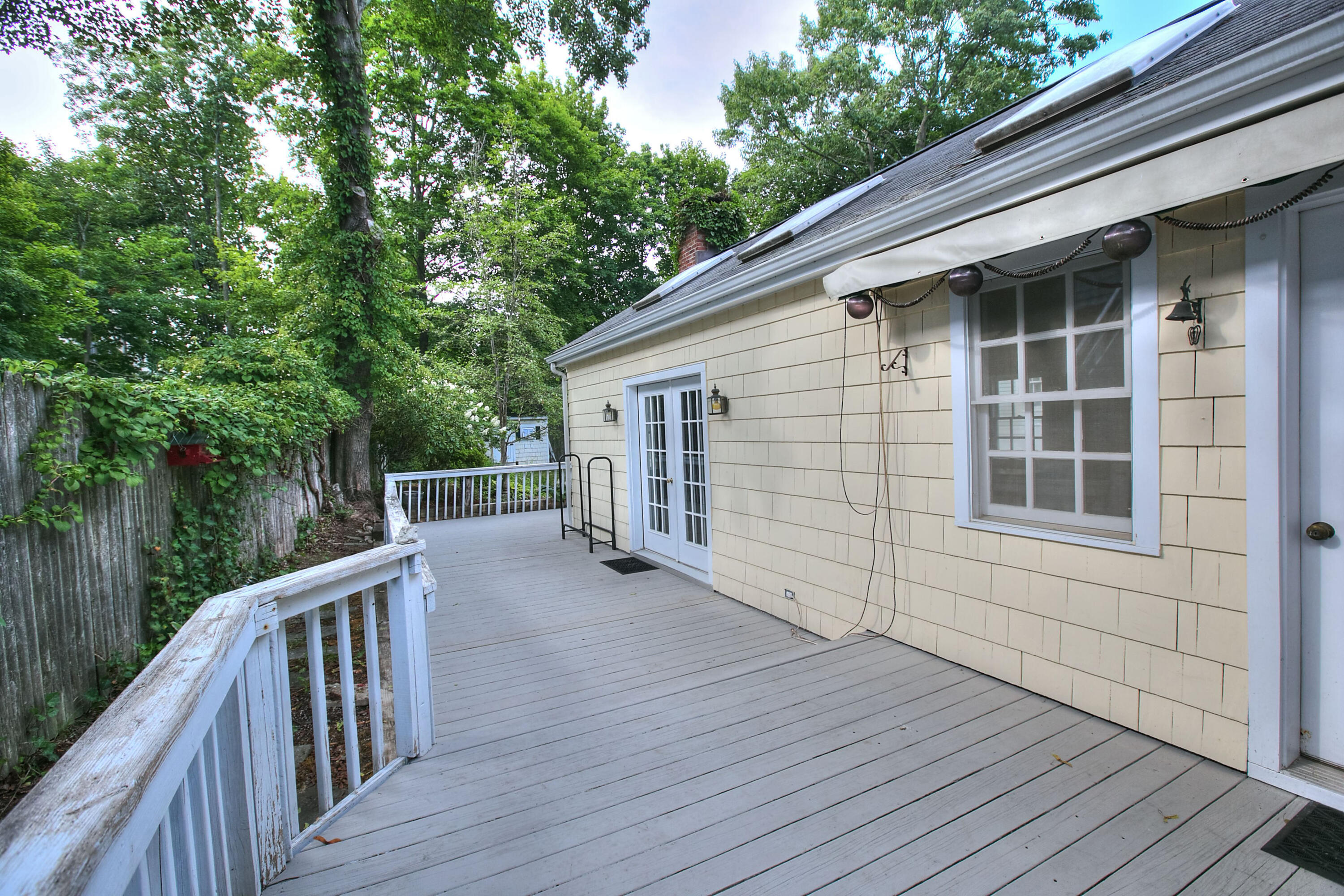 89 Richmond Hill Road New Canaan, CT 06840 - Photo 37 of 40 a view of deck with wooden floor and fence next to a yard