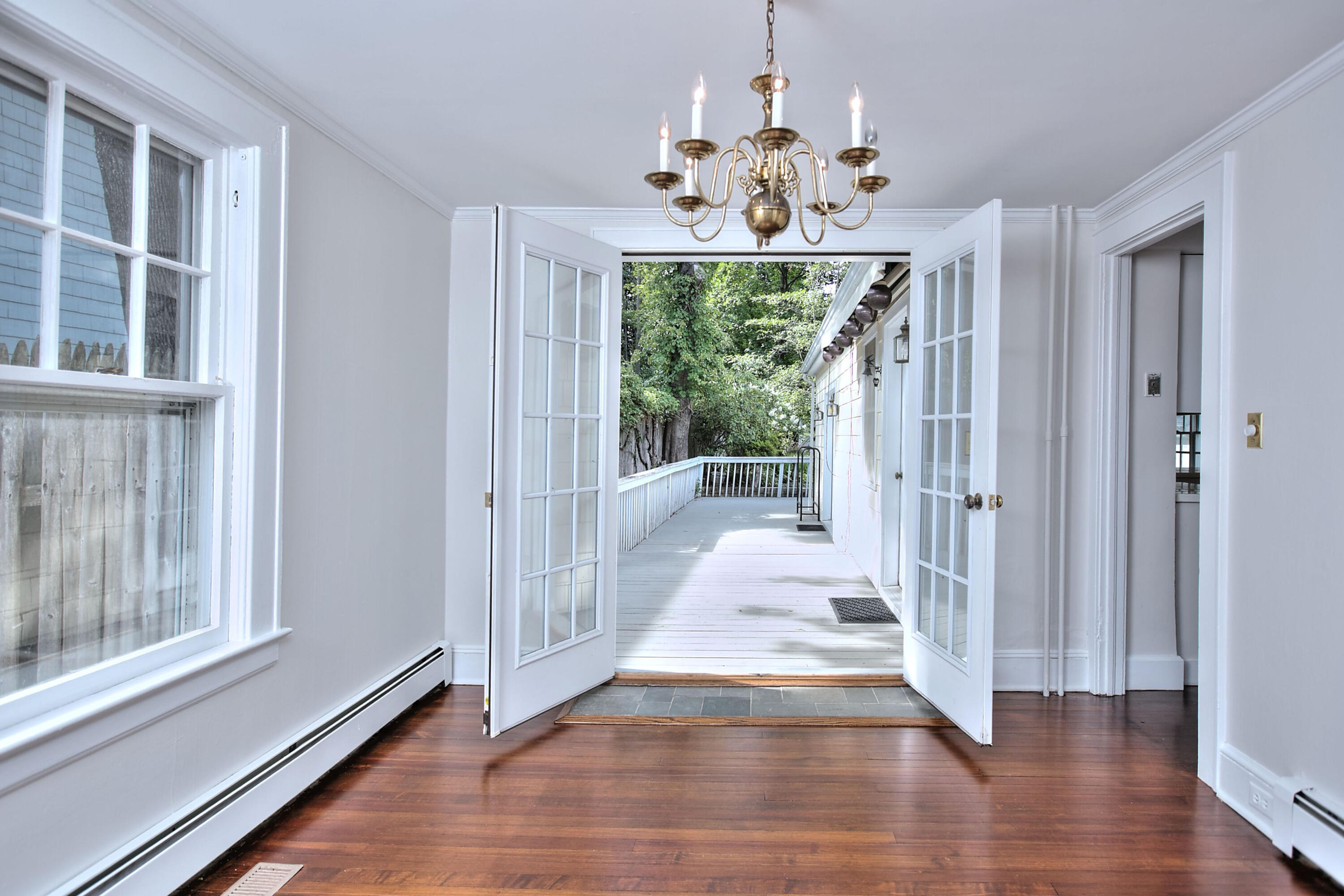 89 Richmond Hill Road New Canaan, CT 06840 - Photo 10 of 40 a view of a hallway with wooden floor and chandelier