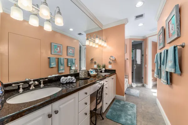 a bathroom with a double vanity sink toilet mirror and shower