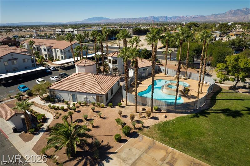 3318 North Decatur Boulevard, Unit 2152 Las Vegas, NV 89130 - Photo 57 of 58 An aerial perspective reveals a sparkling community pool and lush landscaping, set against a mountain backdrop.