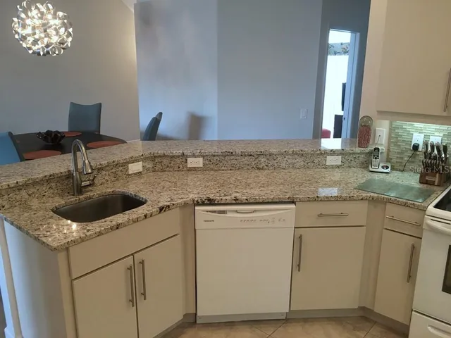 a kitchen with granite countertop a sink and a stove