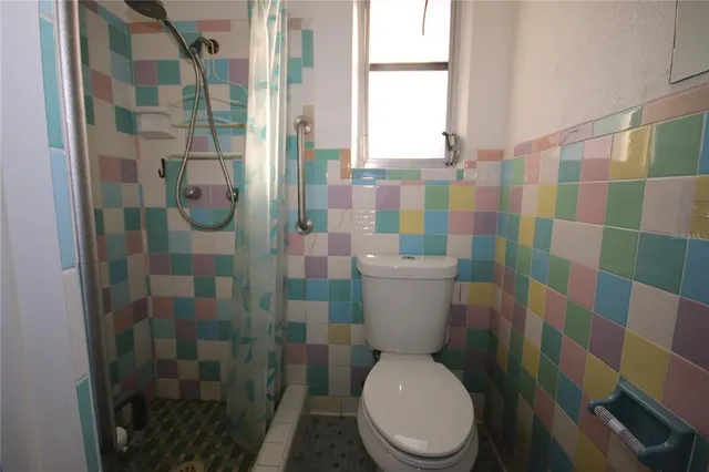 a white toilet sitting next to a bathroom sink and a shower