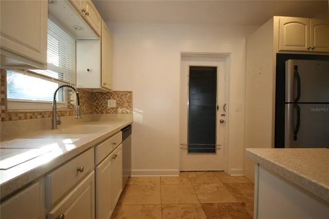 a kitchen with a sink a refrigerator and cabinets