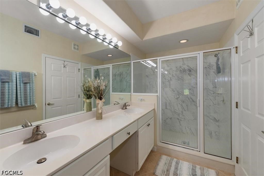 11033 Mill Creek Way, Unit 202 Fort Myers, FL 33913 - Photo 11 of 15 a bathroom with a double vanity sink mirror and shower