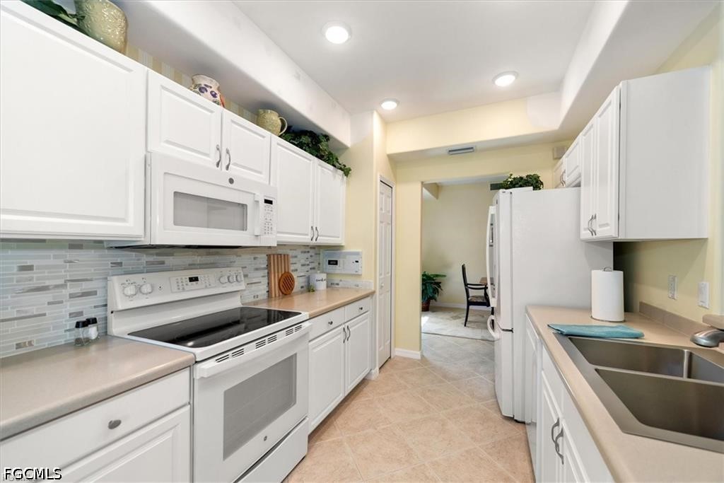 11033 Mill Creek Way, Unit 202 Fort Myers, FL 33913 - Photo 5 of 15 a kitchen with a sink stove and refrigerator