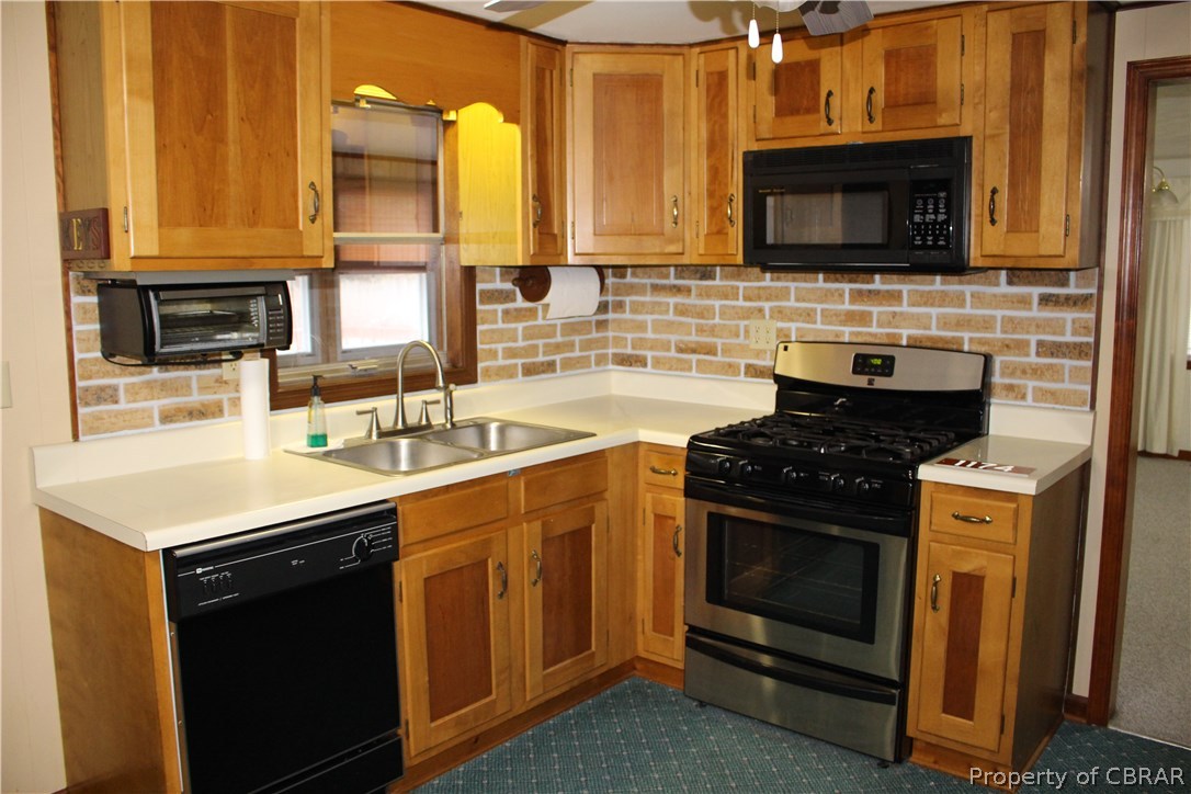 1174 North River Road Bohannon, VA 23021 - Photo 11 of 35 a kitchen with a sink stove and microwave