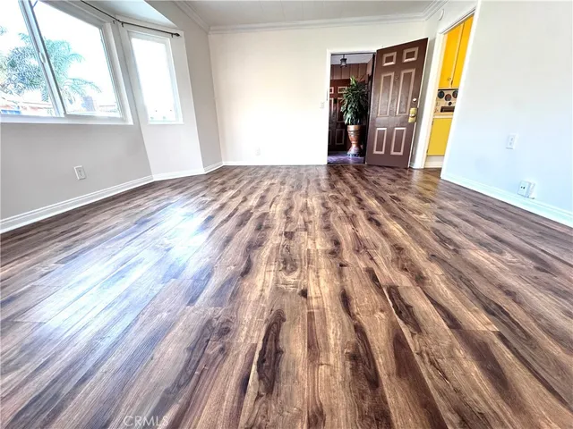 a view of a room with wooden floor and a window