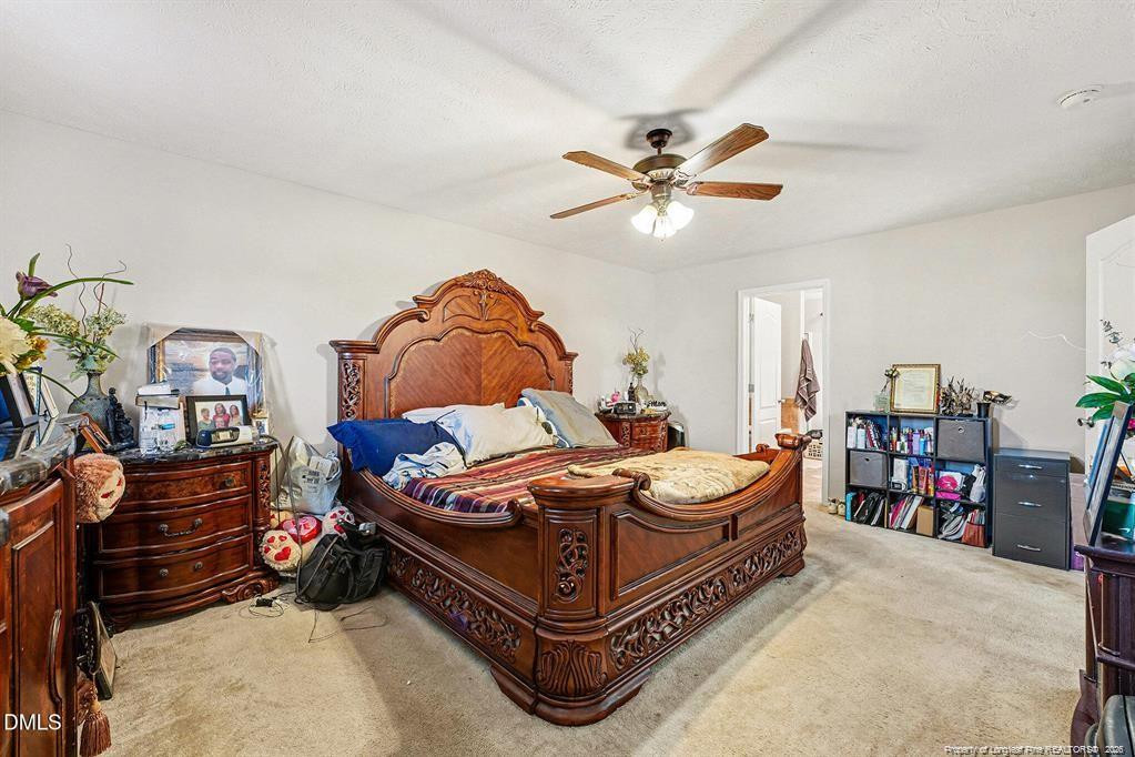 831 Raspberry Road Stedman, NC 28391 - Photo 18 of 35 a bedroom with a bed and a chandelier