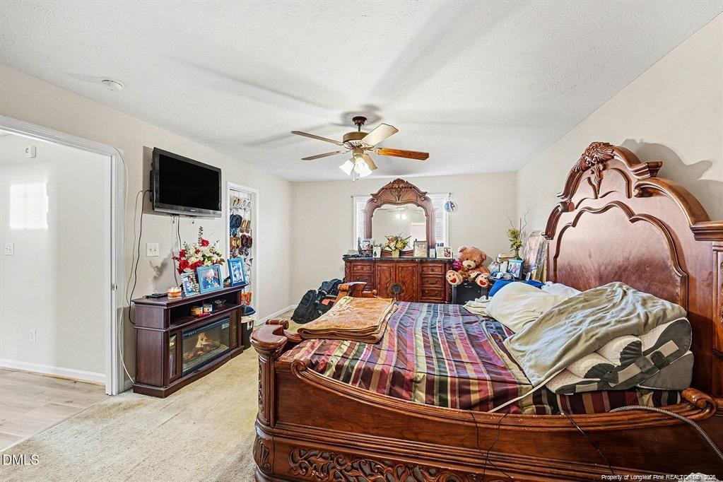 831 Raspberry Road Stedman, NC 28391 - Photo 19 of 35 a living room with a bed and a flat screen tv