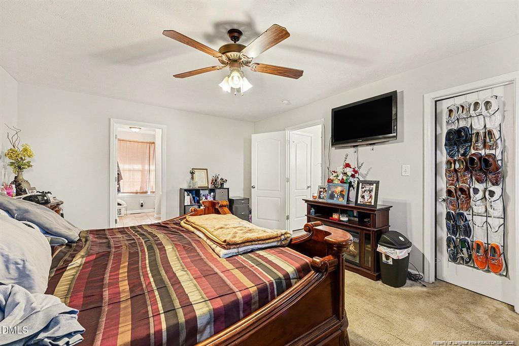 831 Raspberry Road Stedman, NC 28391 - Photo 20 of 35 a bedroom with a bed and a flat screen tv