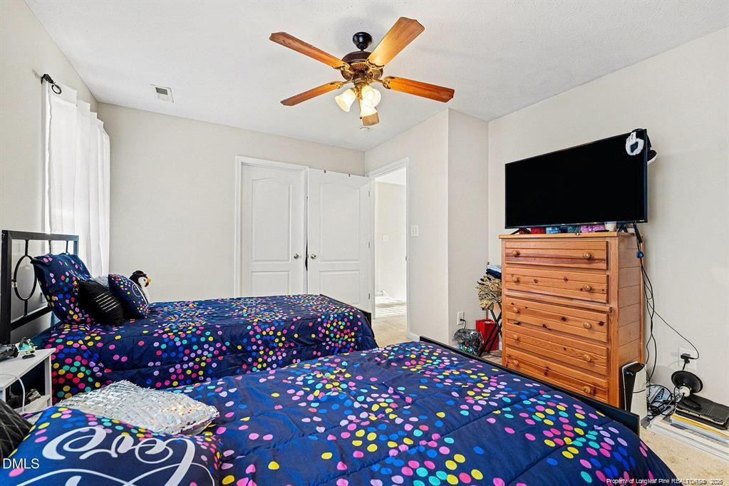 831 Raspberry Road Stedman, NC 28391 - Photo 23 of 35 a bedroom with a bed and flat screen tv