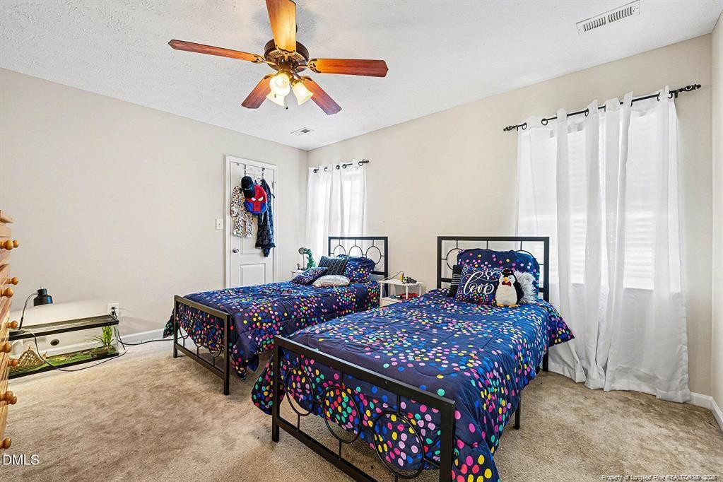 831 Raspberry Road Stedman, NC 28391 - Photo 24 of 35 a bedroom with two beds and a chandelier