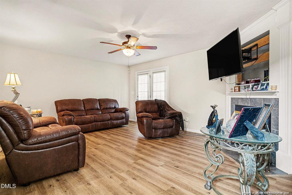 831 Raspberry Road Stedman, NC 28391 - Photo 9 of 35 a living room with furniture a flat screen tv and a fireplace
