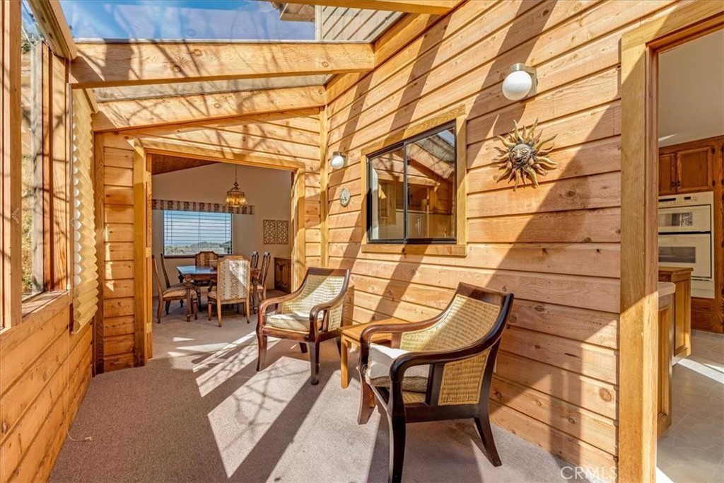 3171 Rogers Road Cambria, CA 93428 - Photo 29 of 73 a view of a patio with table and chairs and floor to ceiling window