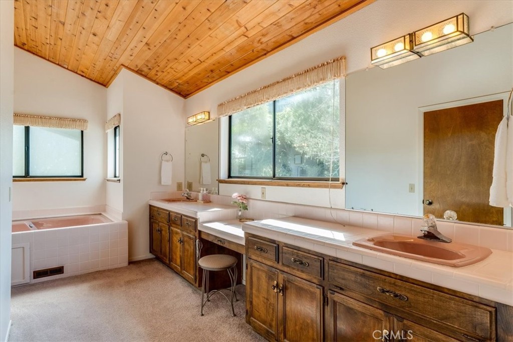 3171 Rogers Road Cambria, CA 93428 - Photo 39 of 73 a spacious bathroom with a double vanity sink a large mirror and a bathtub