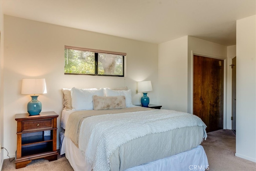 3171 Rogers Road Cambria, CA 93428 - Photo 49 of 73 a bedroom with a bed and a lamp on a dresser