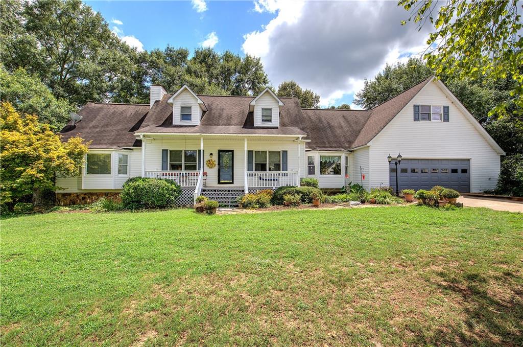 a front view of a house with a garden and yard