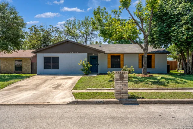 a front view of a house with a garden and plants