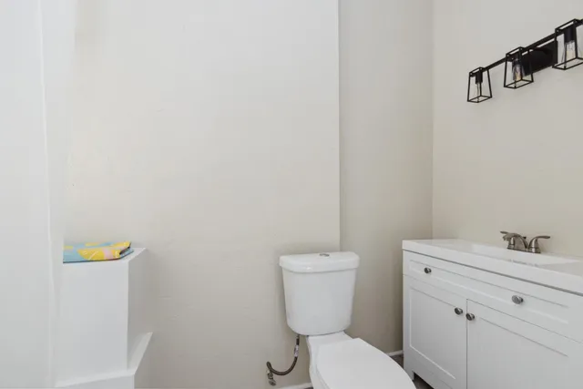 an empty room with wooden floor cabinet and windows
