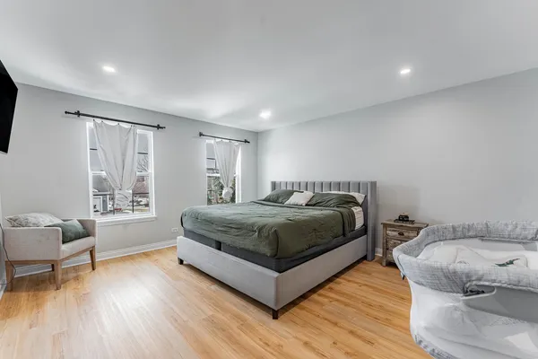 a bedroom with a bed and wooden floor
