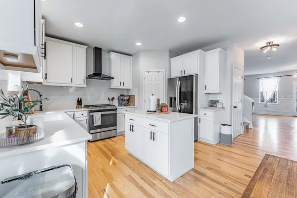 a kitchen with white cabinets and stainless steel appliances