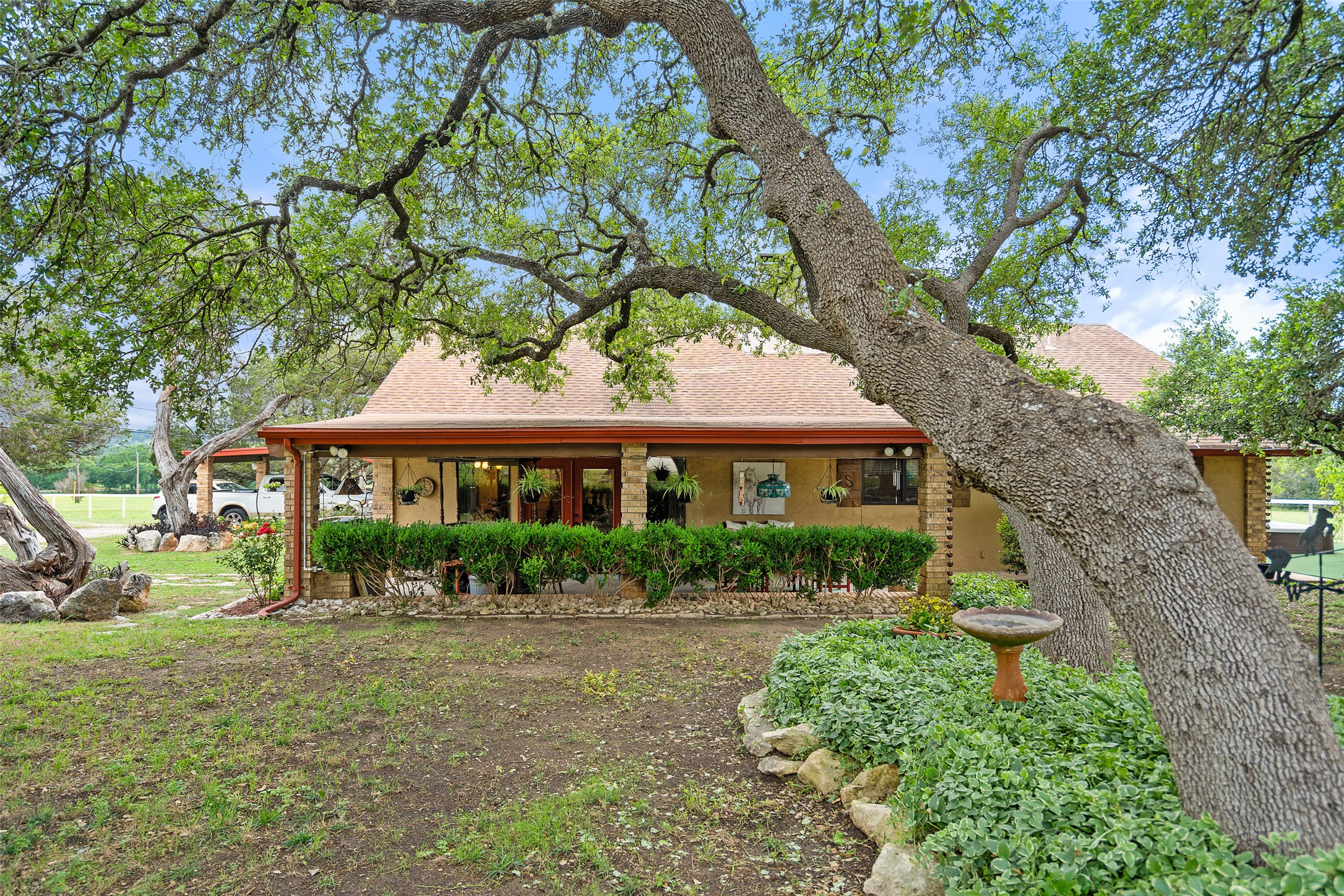 23200 Fulkes Road Leander, TX 78641 - Photo 14 of 15 Mature trees frame a charming home with a welcoming front porch and manicured landscaping.
