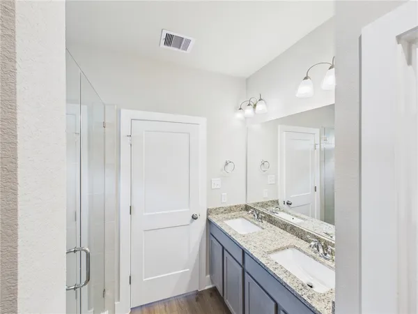 a bathroom with a granite countertop sink a mirror and a shower