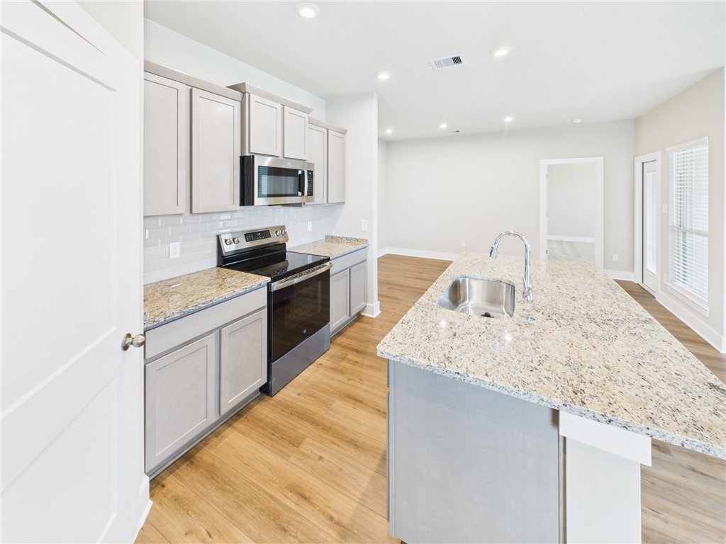 5306 Lyle Place Bryan, TX 77807 - Photo 5 of 18 a kitchen with stainless steel appliances granite countertop a sink stove microwave and refrigerator