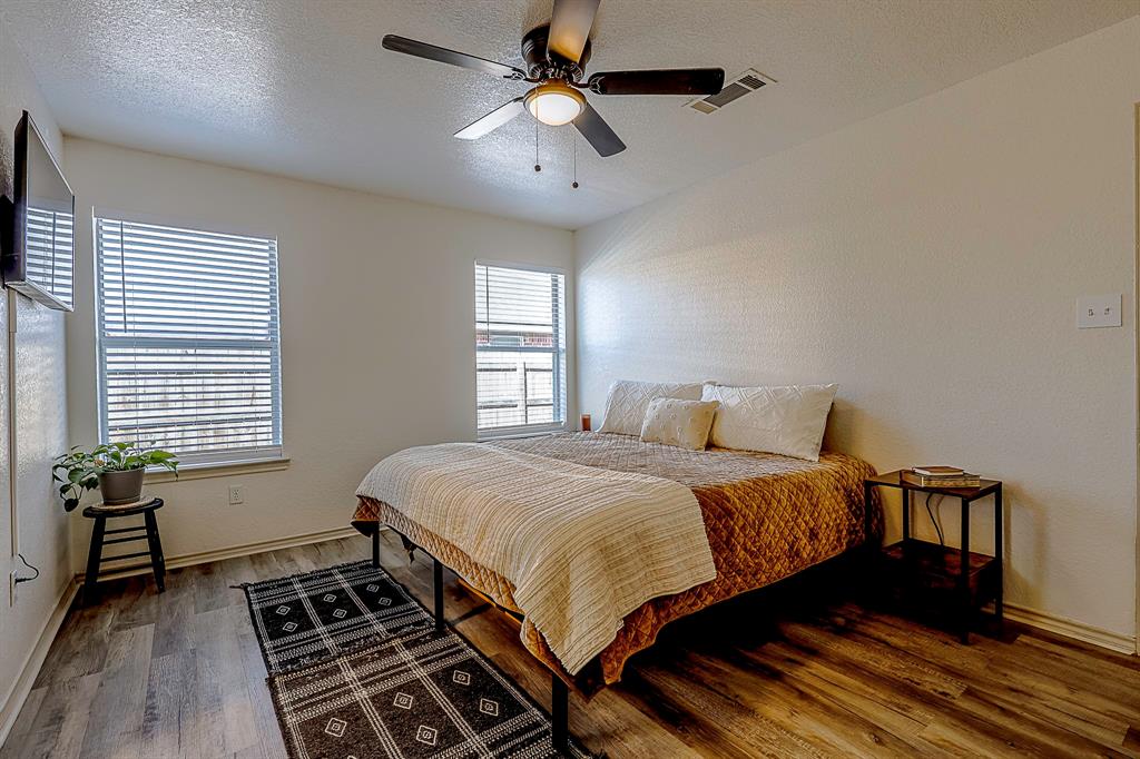 10812 Lilry Road Waco, TX 76708 - Photo 13 of 25 Bedroom featuring a textured ceiling, dark wood finished floors, and a ceiling fan