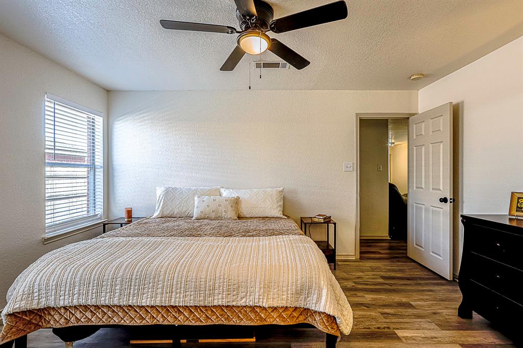 10812 Lilry Road Waco, TX 76708 - Photo 14 of 25 Bedroom featuring a textured ceiling, dark wood-type flooring, a textured wall, and ceiling fan