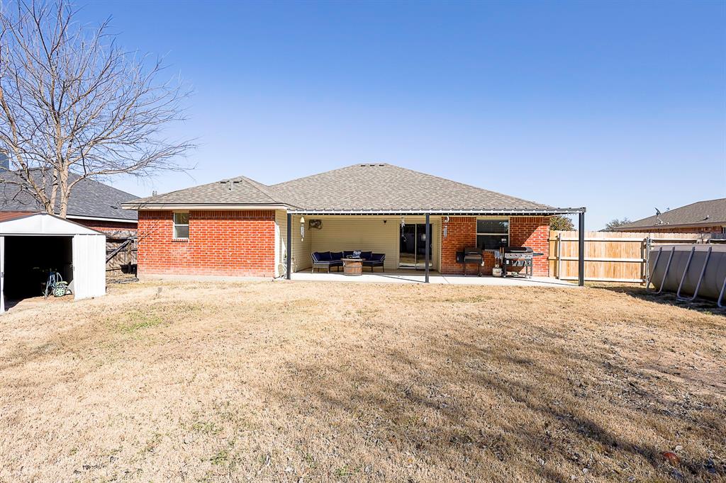 10812 Lilry Road Waco, TX 76708 - Photo 24 of 25 Back of property featuring a patio area, a shed, brick siding, and roof with shingles
