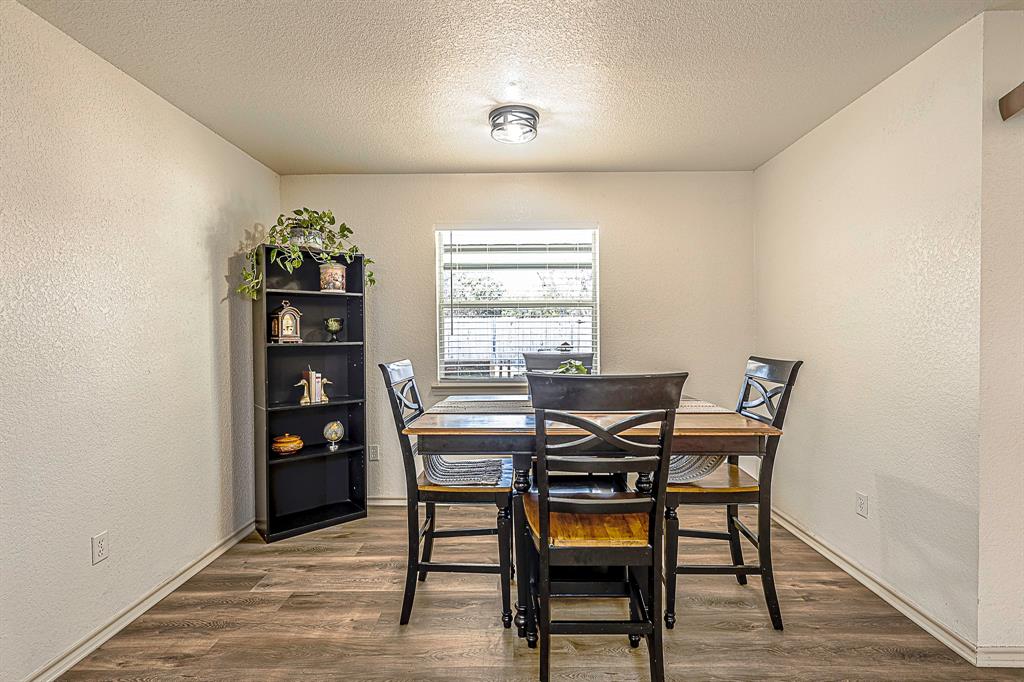 10812 Lilry Road Waco, TX 76708 - Photo 8 of 25 Dining room featuring a textured wall, a textured ceiling, and dark wood-type flooring