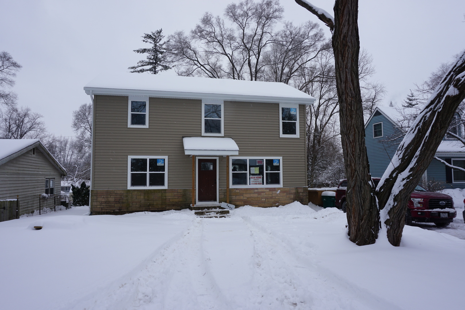 a view of a house with a yard covered in snow