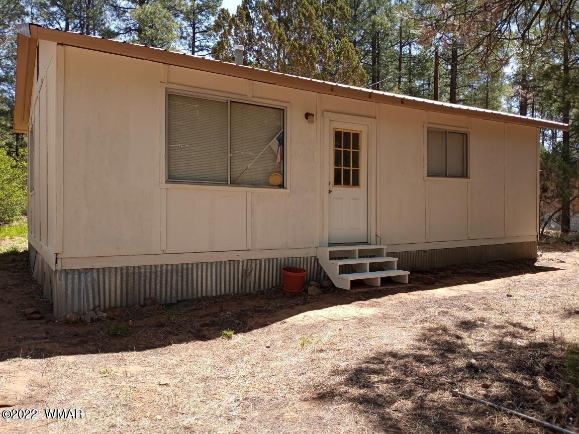 2891 Tracy Road Overgaard, AZ 85933 - Photo 1 of 9 a front view of a house with a yard