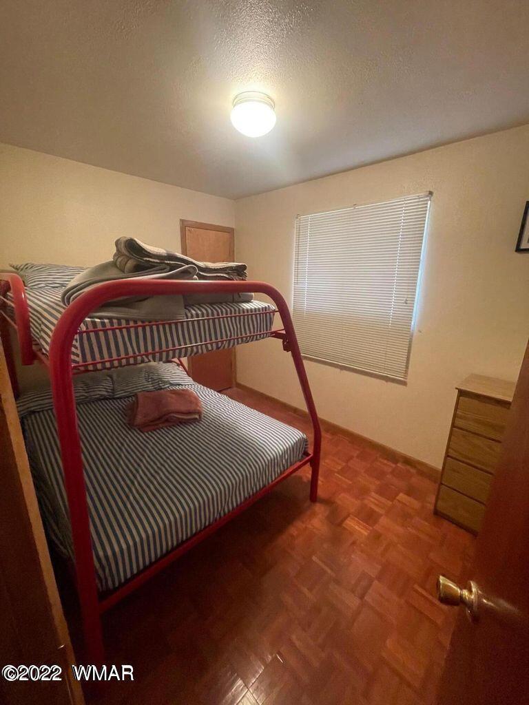 2891 Tracy Road Overgaard, AZ 85933 - Photo 7 of 9 a bedroom with a bed and wooden floor