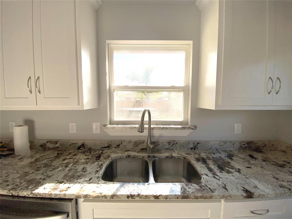 3130 Hillglenn Road Dallas, TX 75228 - Photo 8 of 10 Kitchen sink area featuring a dual-basin stainless steel sink, a brushed nickel gooseneck faucet, and light-toned, veined countertops