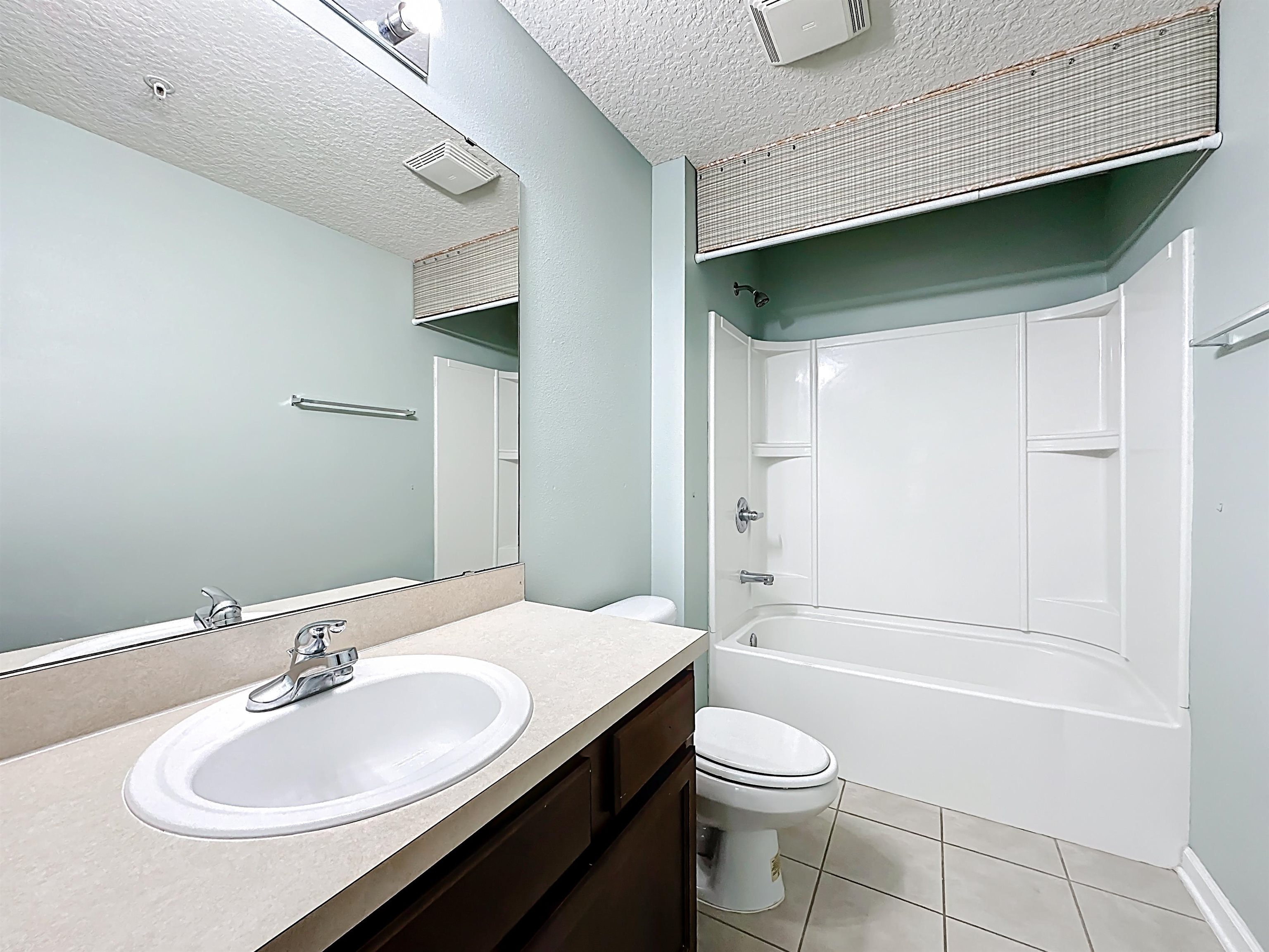 240 Golden Lake Loop St. Augustine, FL 32084 - Photo 18 of 31 Bathroom with vanity, shower combination, a textured ceiling, and light tile patterned floors
