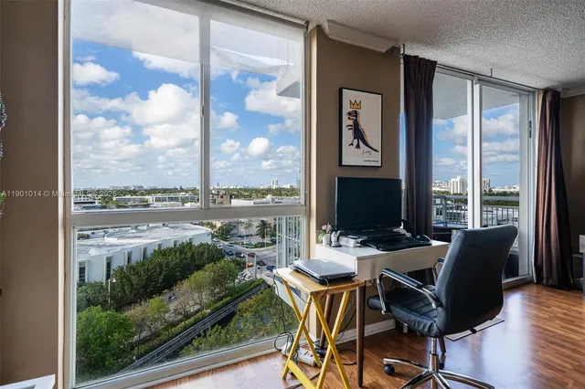 a view of a workspace with furniture and a window