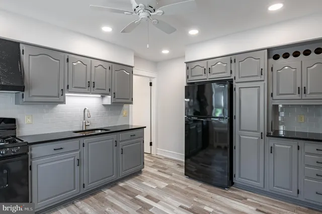 a kitchen with kitchen island granite countertop appliances cabinets and a sink